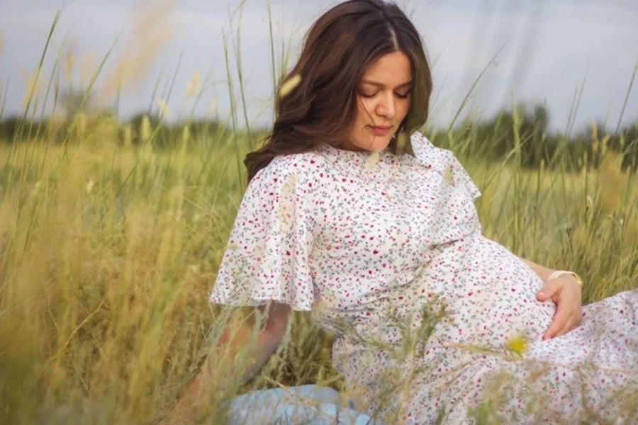 Uma mulher grávida em um vestido de maternidade estampado floral