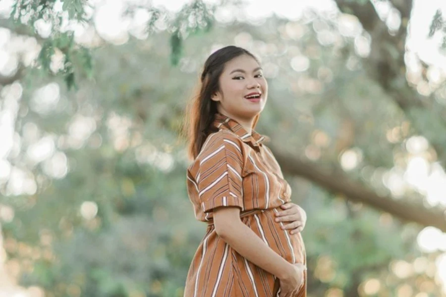 Seorang wanita hamil dengan baju kemeja bergaris