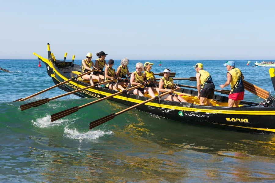 Eine Gruppe von Menschen, die ein schwarzes Boot rudern