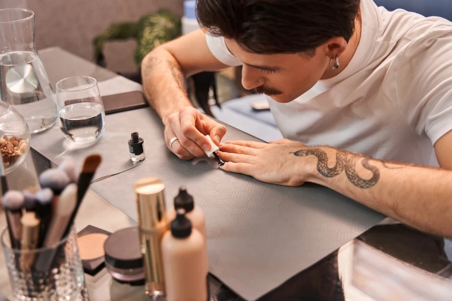 Homem pintando as unhas de preto