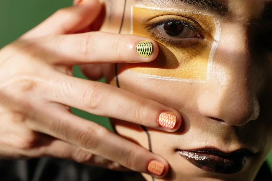 Uomo che mostra la sua nail art con la mano davanti al viso