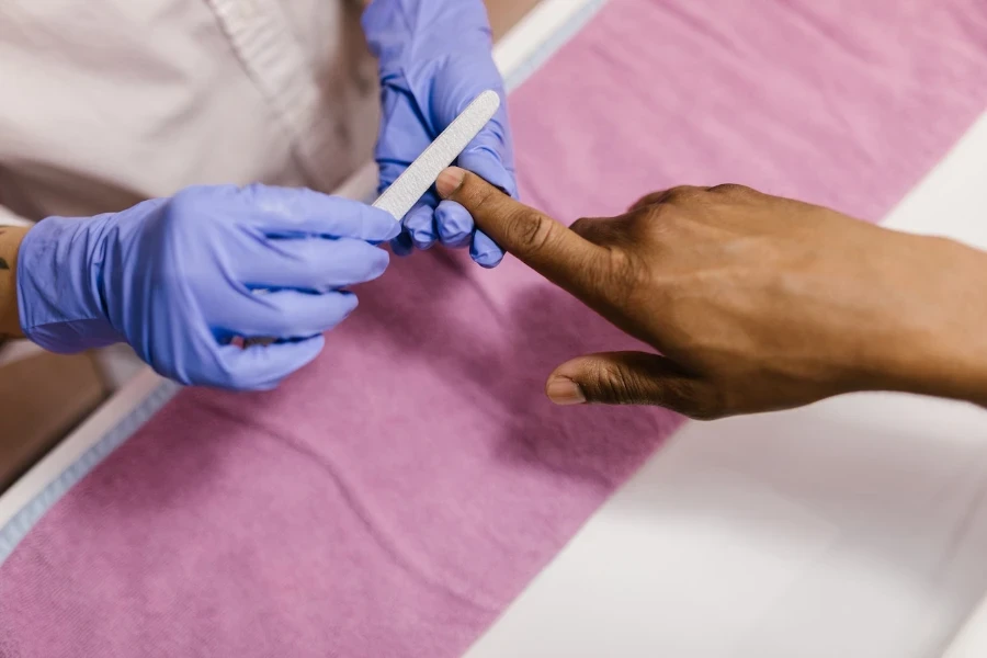 Person getting their nails filed during a manicure