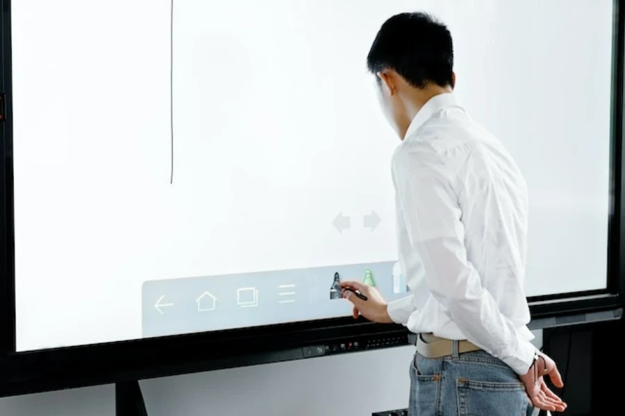 Un jeune homme utilisant un tableau blanc interactif