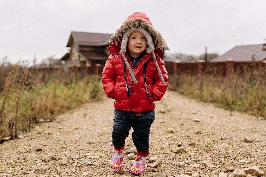 Junge mit Händen in den Taschen einer wattierten Jacke