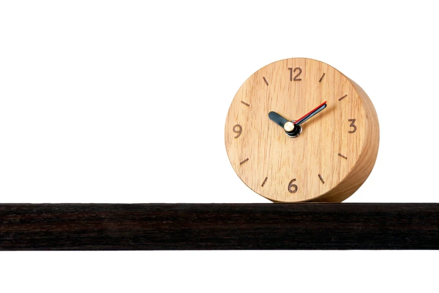 Reloj de diseño clásico retro de madera con alarma marrón colocado en un estante con fondo blanco aislado de las diez en punto