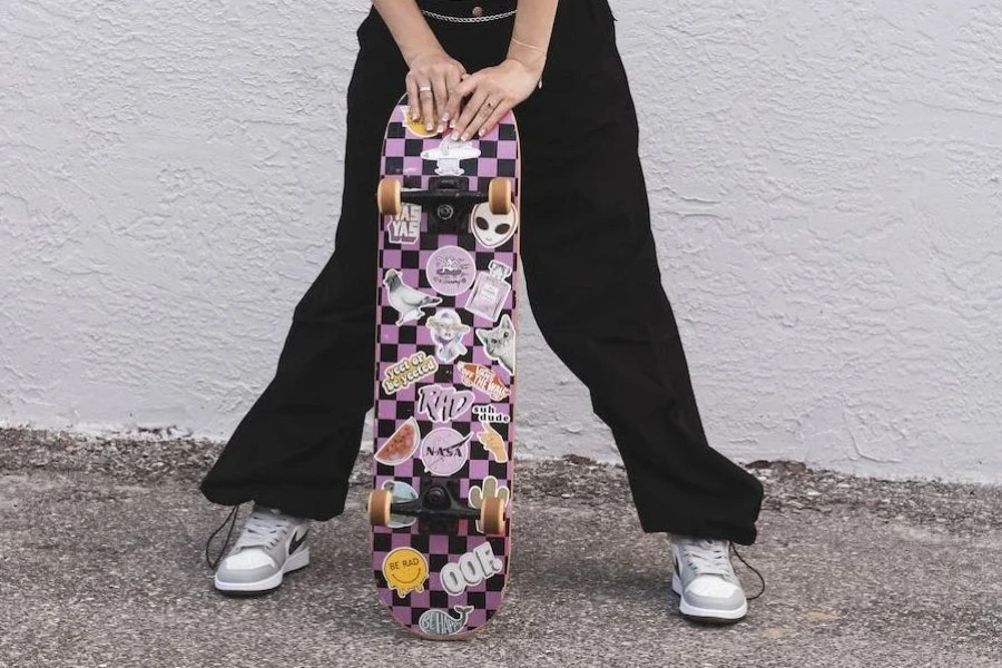 Immagine ritagliata di una ragazza skater con pantaloni oversize neri