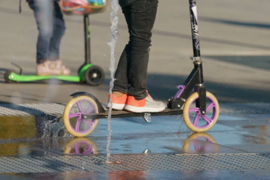 Person steht auf einem Roller mit großen lila Rädern