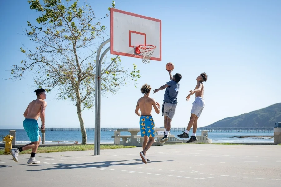 Spieler, die einen in den Boden eingelassenen Basketballkorb benutzen