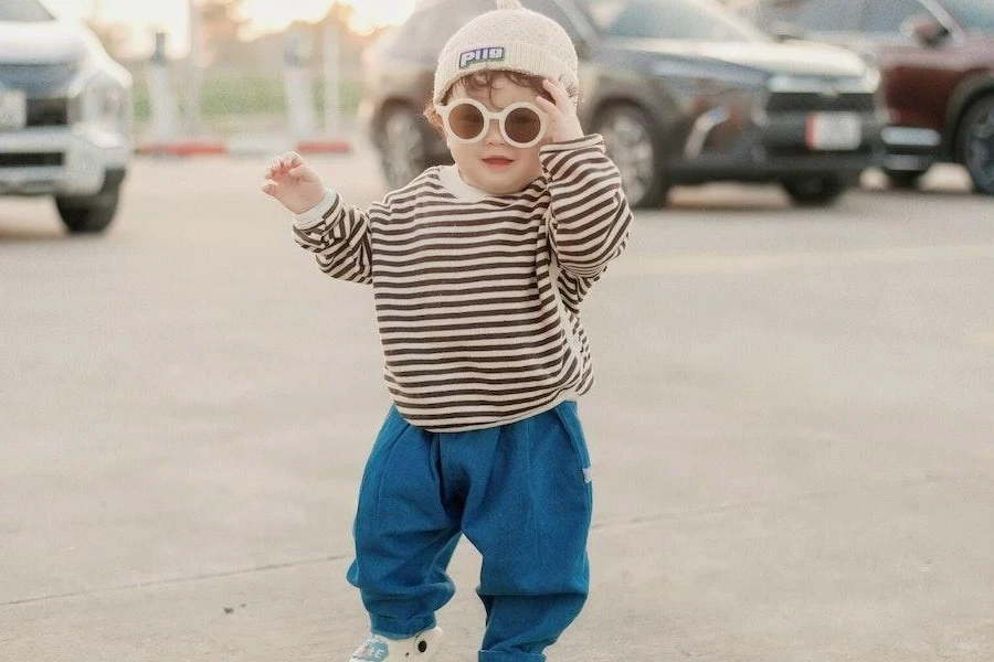 Stylish boy in a striped sweatshirt and blue joggers