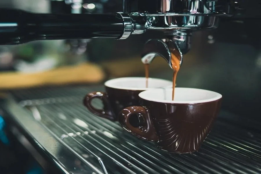 Two coffee mugs under a coffee maker