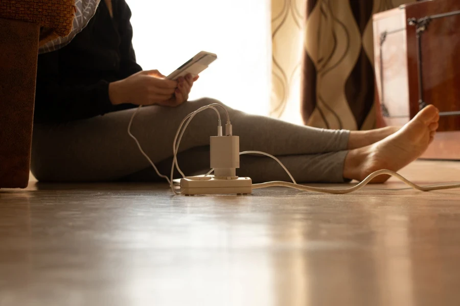 Mujer cargando su teléfono en su apartamento.