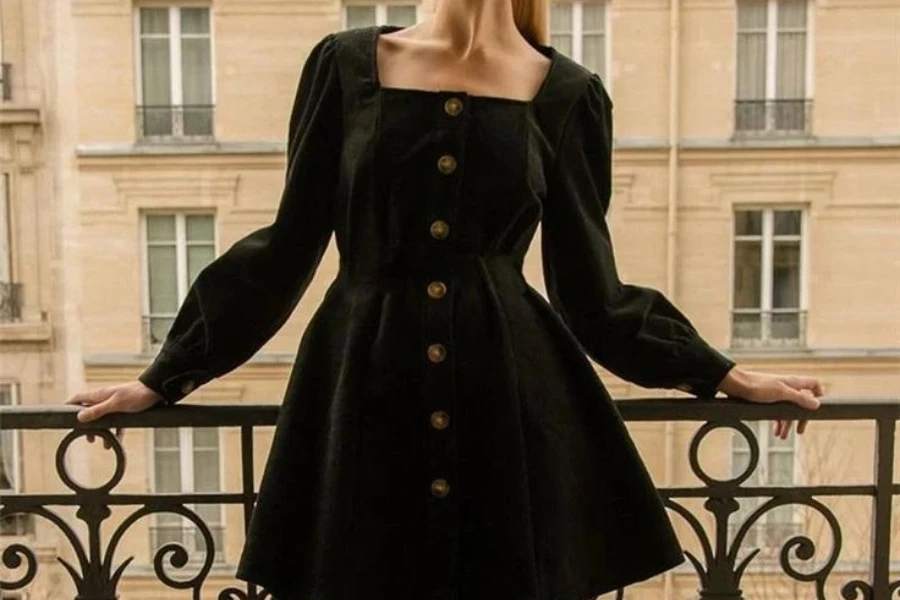 Femme sur un balcon vêtue d'une robe noire à manches longues