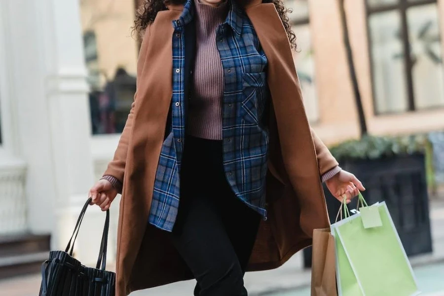 Mujer vistiendo una chaqueta marrón de gran tamaño sobre una camisa a cuadros