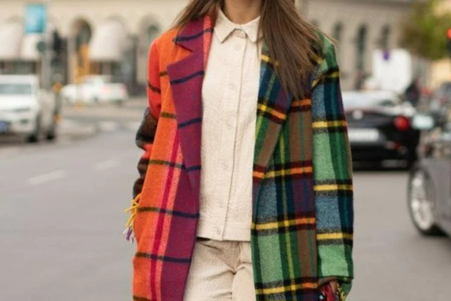 Donna che indossa un cappotto di tendenza a quadri multicolori