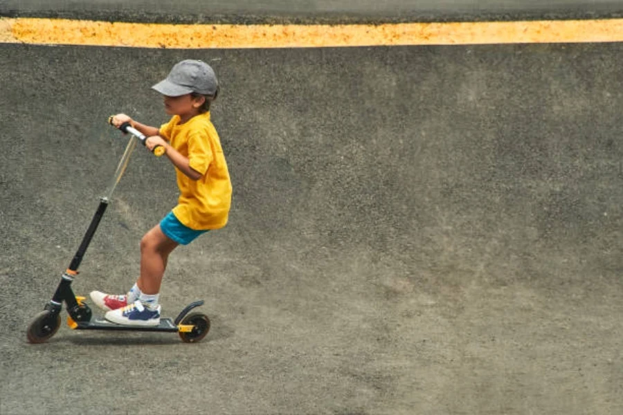 Niño jugando en el parque de patinaje con una scooter