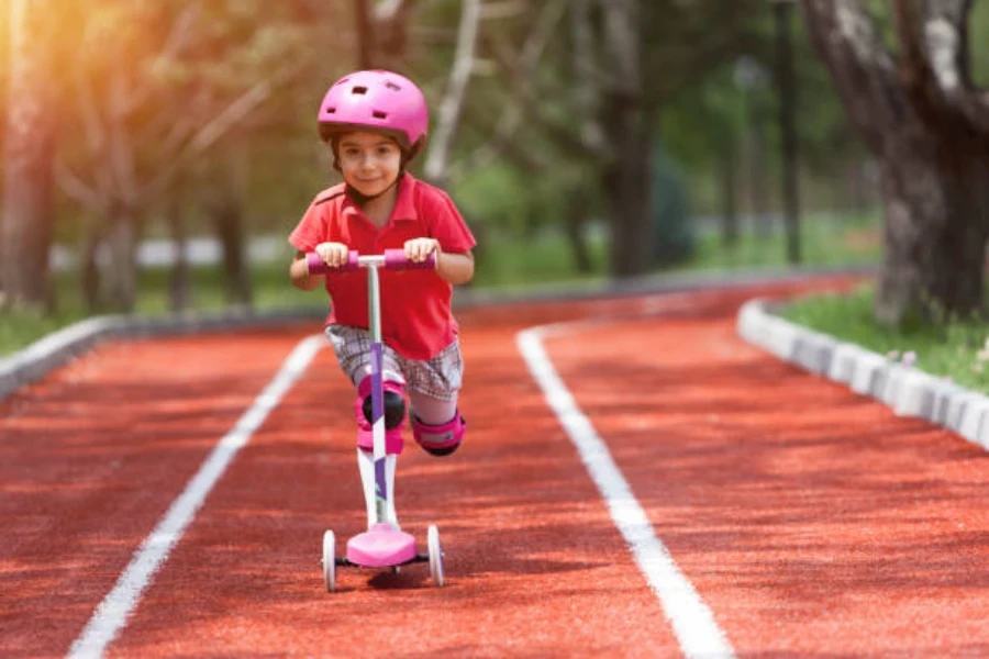 Jeune fille poussant un scooter rose avec un casque rose