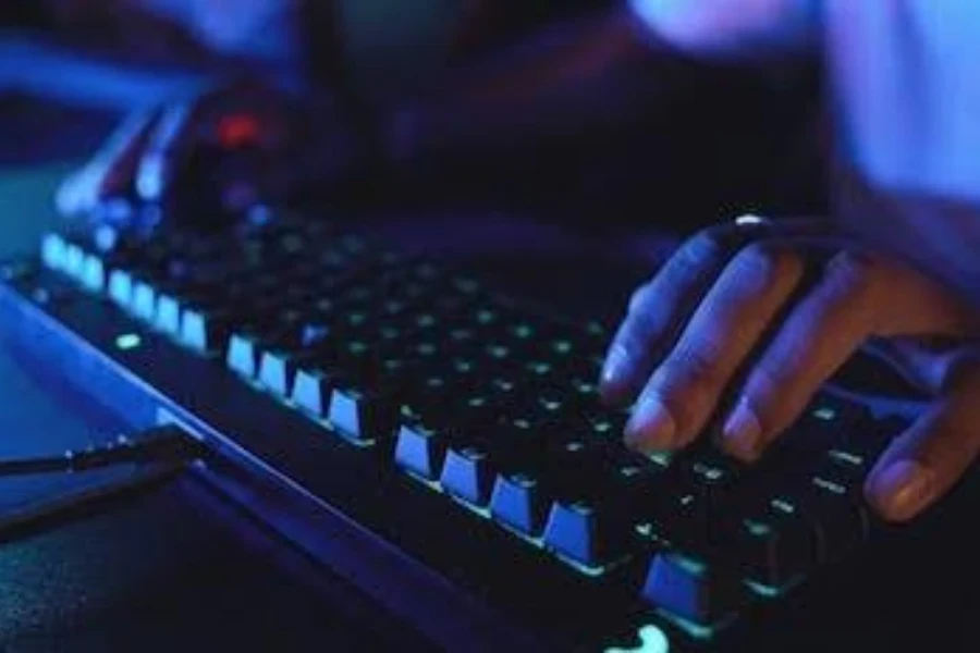 Seorang gamer dengan dua tangan pada keyboard gaming hybrid