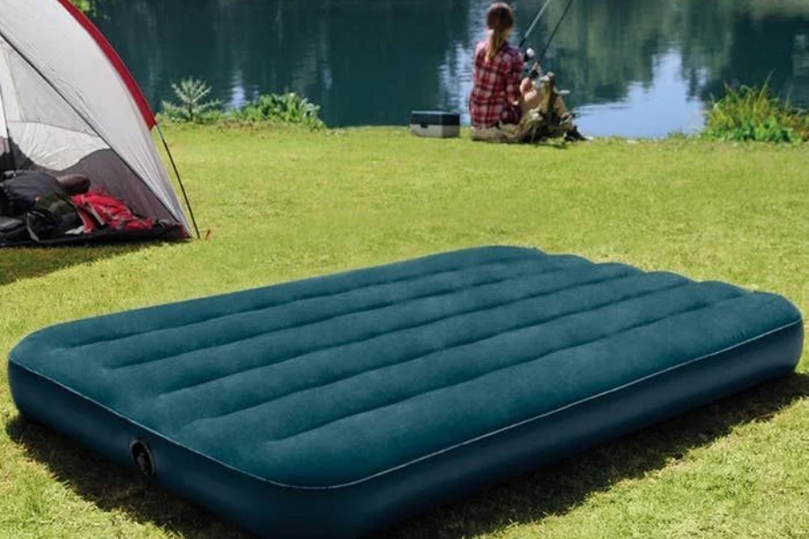 Un matelas pneumatique gonflé vert sur un terrain en herbe