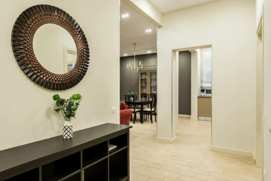 A round wall mirror hung in a hallway