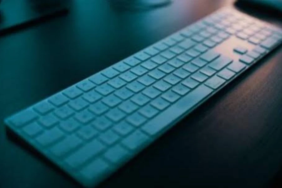 Um teclado para jogos de membrana branca em uma mesa elegante