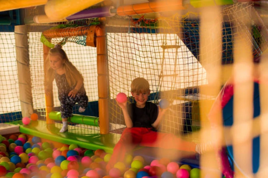 Kinder spielen in einem Bällebad auf einem Indoor-Spielplatz