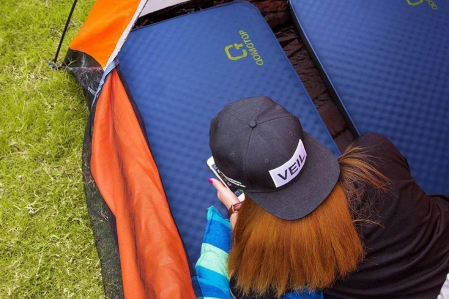 Lady resting on two closed-foam camping beds