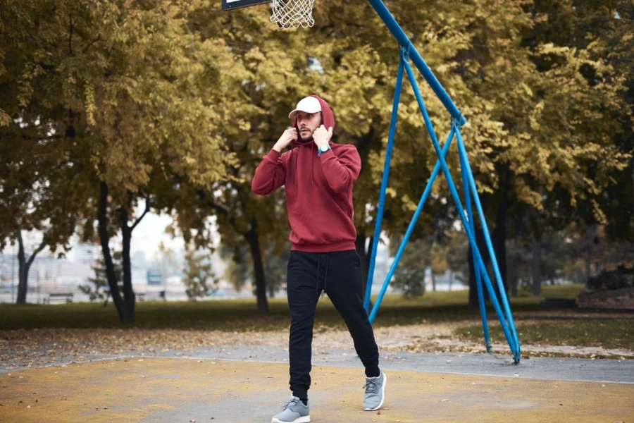 uomo in felpa con cappuccio e pantaloni della tuta