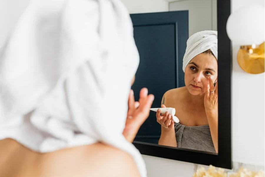 Mirror reflection of a person applying moisturizer