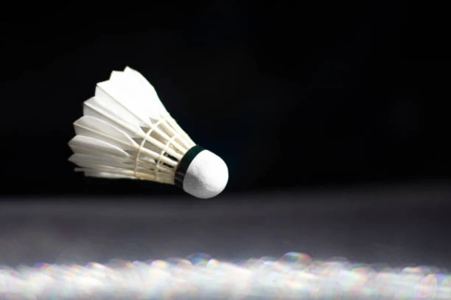 White feathered shuttlecock flying through the air indoors