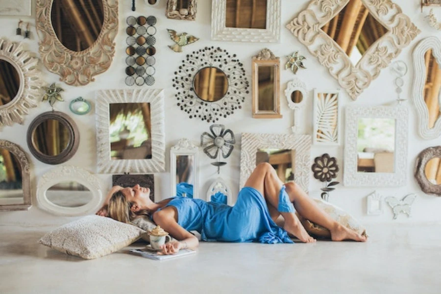 Woman lying on the floor near decorative wall mirrors