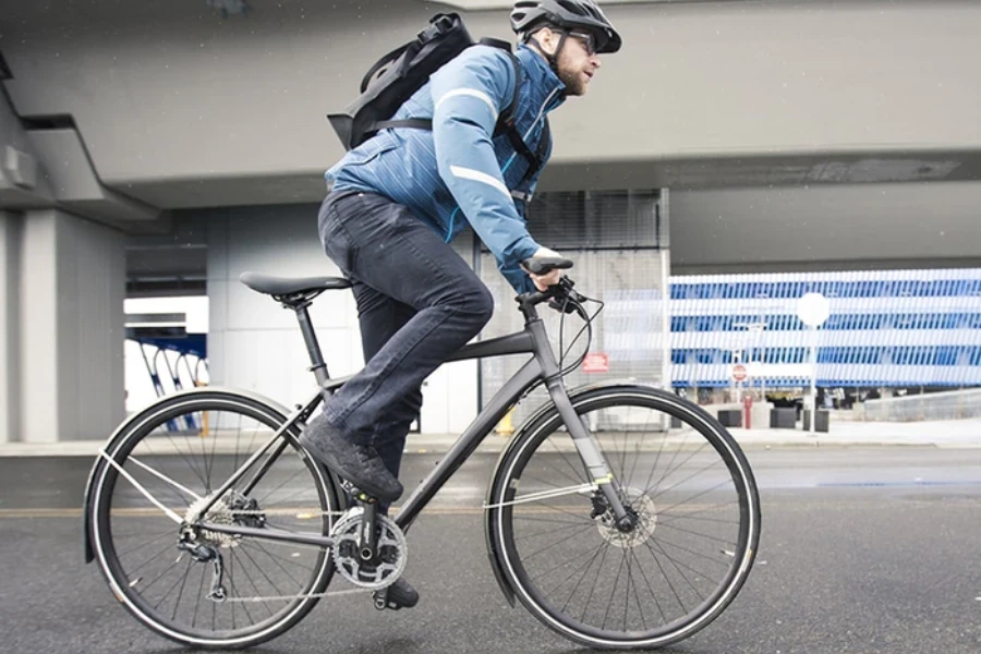 都市部の路上でクロスバイクに乗っている男性