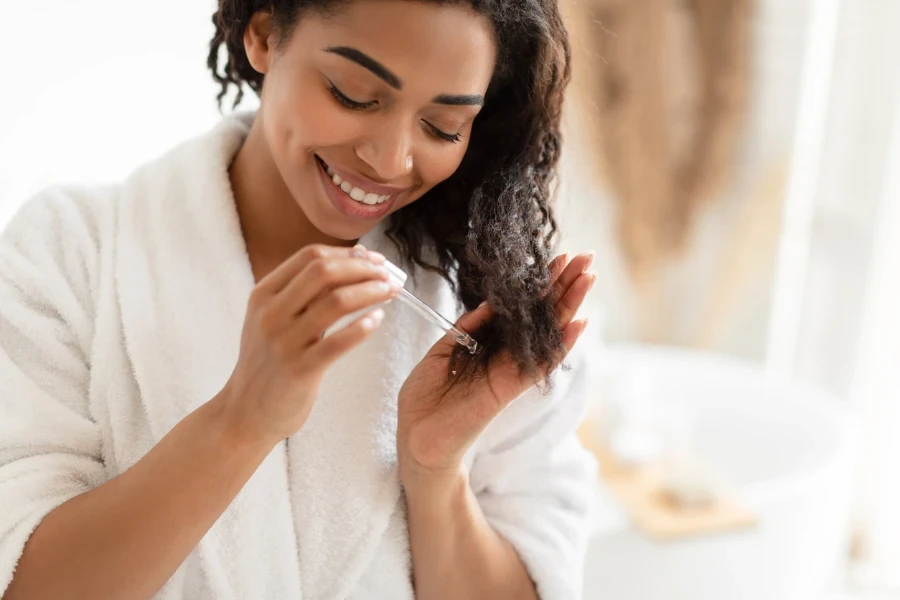 uma mulher aplicando soro no cabelo