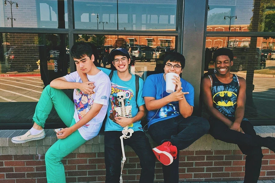 four teen boys sitting on the platform