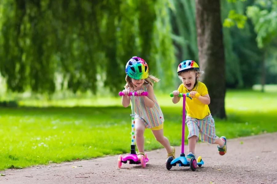 Renkli scooterlara binen küçük mutlu çocuklar