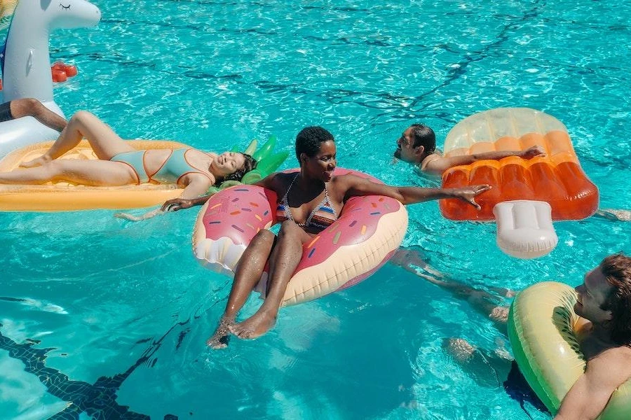 Pessoas relaxando em uma piscina em diferentes carros alegóricos