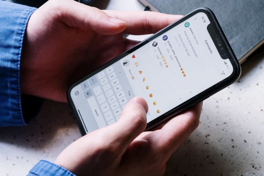 Persona in possesso di uno smartphone che legge i commenti sui social media