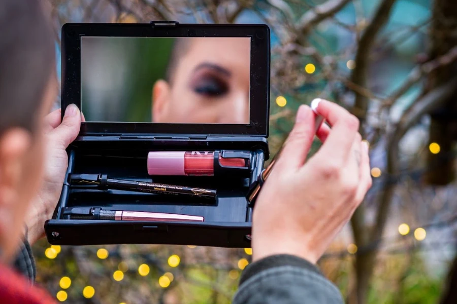 Person looking in a portable makeup mirror