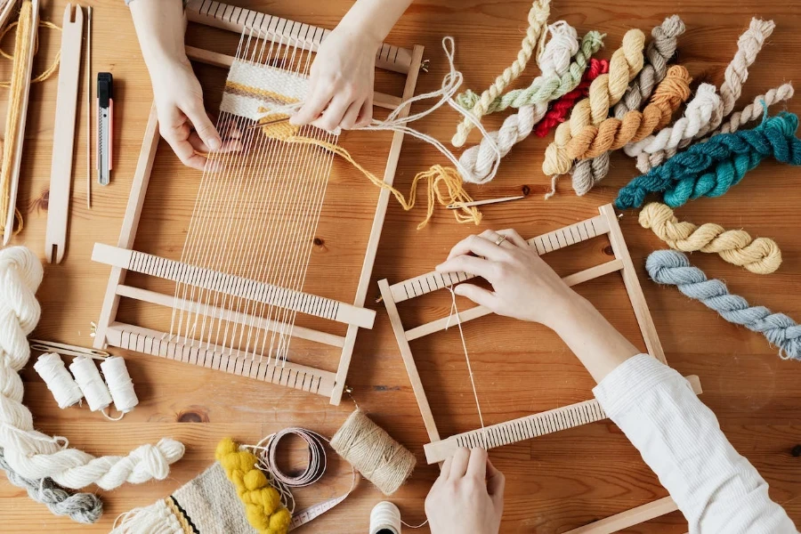 Top view photo of two persons’ hands weaving