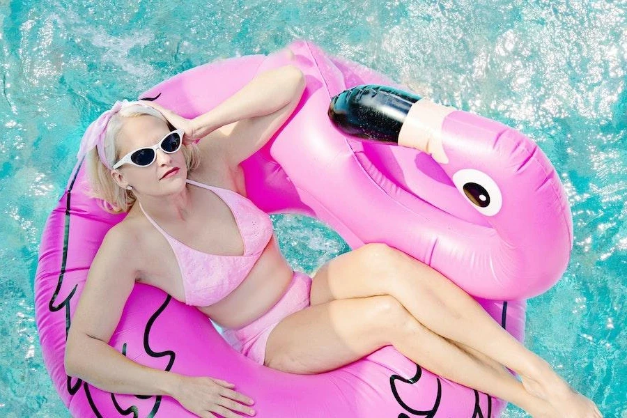 Mujer en un flotador con forma de flamenco relajándose en una piscina