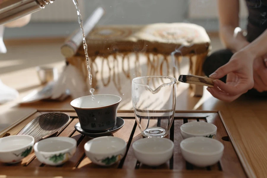 Una persona vertiendo agua caliente sobre el té.