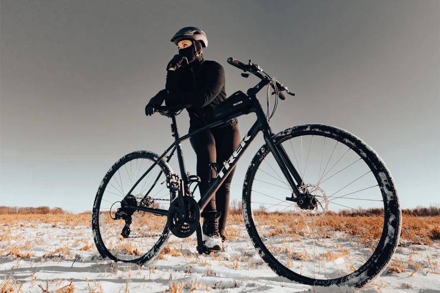 uma mulher parada ao lado de uma bicicleta de estrada