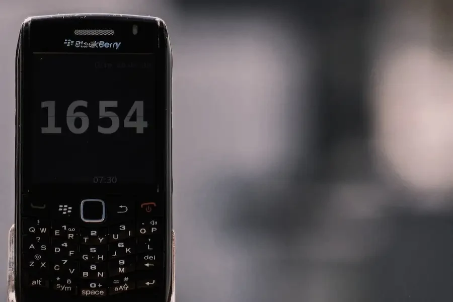 Black BlackBerry phone displaying the time