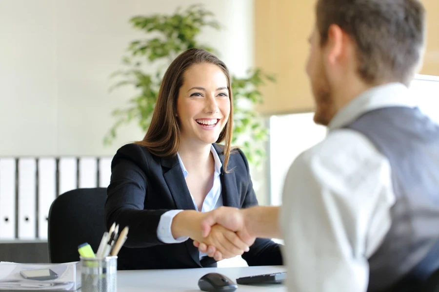 empresária apertando a mão de um cliente satisfeito