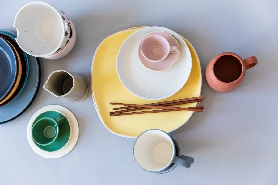 Tazas de té de cerámica con platos y palillos de madera.