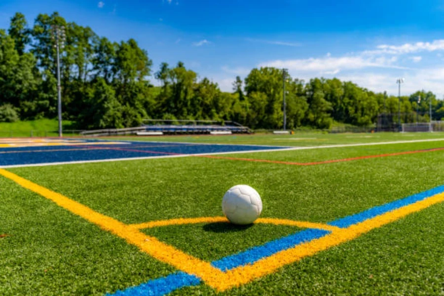 Sepak bola duduk di sudut lapangan yang terbuat dari rumput buatan