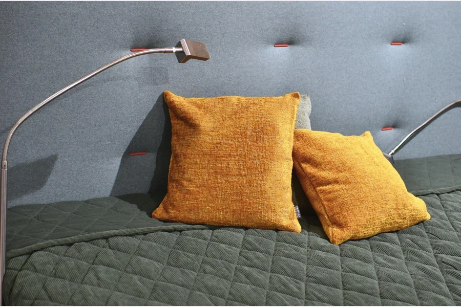 orange pillows on a grey bed