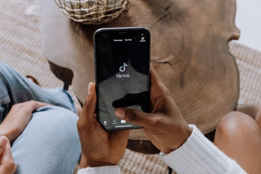 Personne tenant un smartphone pendant le chargement de l'application TikTok