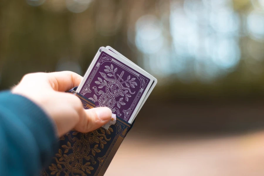 Pessoa tirando um baralho de cartas de plástico da caixa