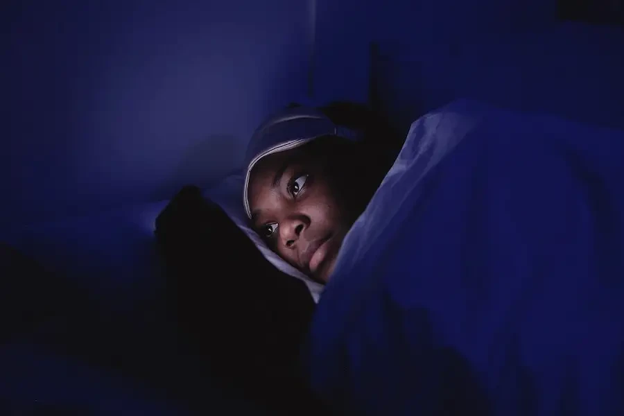 Mujer usando un teléfono celular durante la hora de dormir