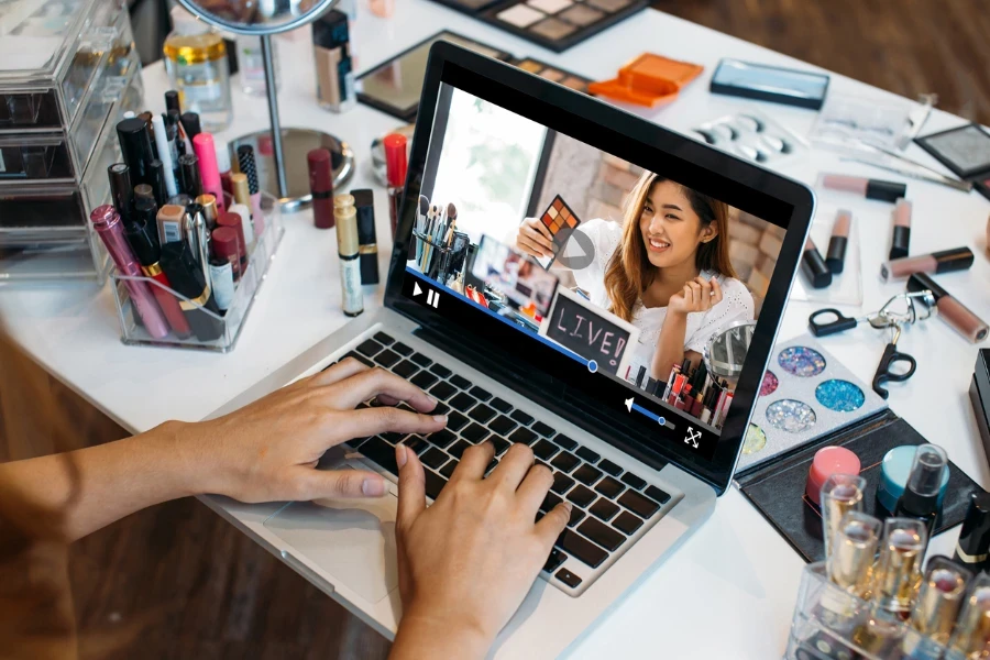 Frau mit den Händen auf dem Laptop, die ein Live-Video ansieht